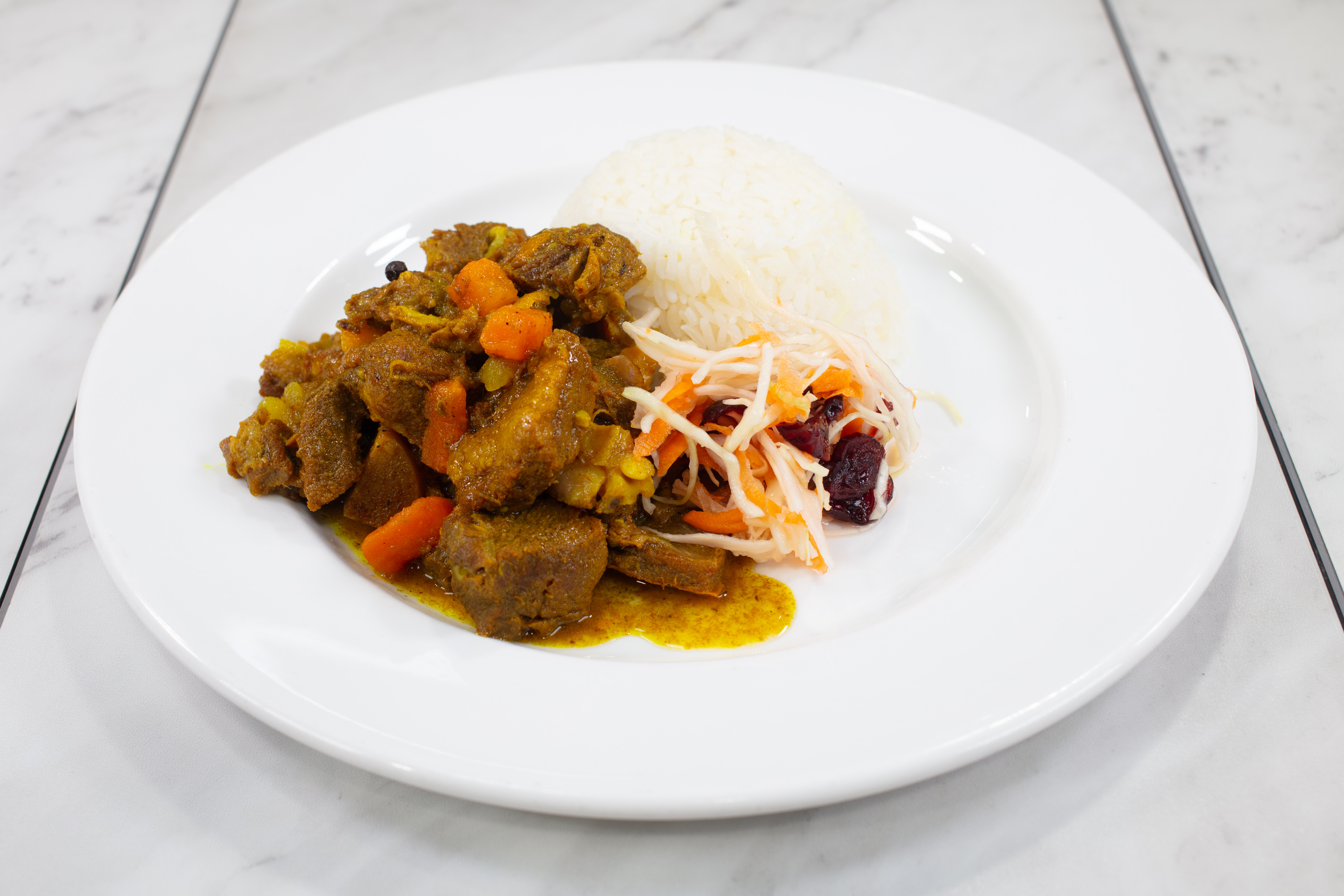 Curry goat meal with rice and vegetables